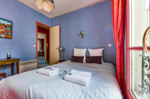 une chambre avec un grand lit avec deux serviettes dessus dans l'établissement Le Rubis de Paris élégant Notre-Dame & Panthéon, à Paris