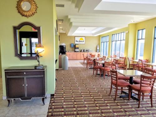 a dining room with tables and chairs and a mirror at Days Inn by Wyndham Windsor Locks / Bradley Intl Airport in Windsor Locks