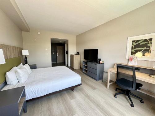 a hotel room with a bed and a desk and a computer at Country Inn & Suites by Radisson, Port Charlotte, FL in Port Charlotte