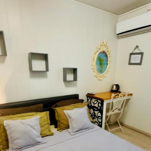 a bedroom with a bed with yellow pillows and a table at Villa Mayana Studios ou chambre Business in Dzaoudzi
