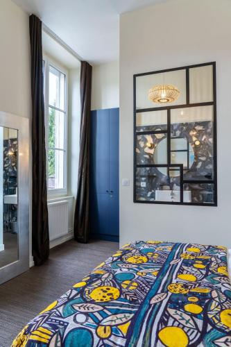 - une chambre avec un lit doté d'un couvre-lit coloré dans l'établissement Zeina, 2 pièces confortables et raffinées, wifi, hypercentre, à La Rochelle
