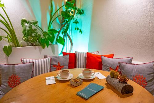 a wooden table with two cups on top of it at Sigacik Gardenya Buti̇k Otel in Siğacık