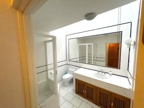 a bathroom with a sink and a mirror and a toilet at Casa En Campo de Golf, Lomas de Cocoyoc in Texcalpan