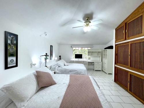 a bedroom with two beds and a ceiling fan at Casa En Campo de Golf, Lomas de Cocoyoc in Texcalpan