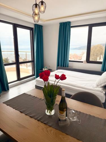 a bedroom with a table with flowers and a bottle of wine at ORA SeaView in Balchik