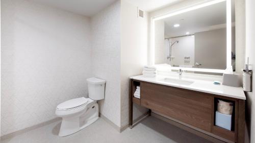a bathroom with a toilet and a sink and a mirror at Holiday Inn Express Hotel & Suites Waterloo - St. Jacobs Area by IHG in Waterloo
