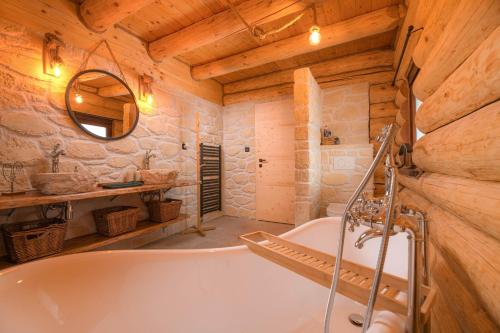 a bathroom with a bath tub and a mirror at Forest Chalet with Jacuzzi and sauna, 4 km from Starý Smokovec in Nová Lesná