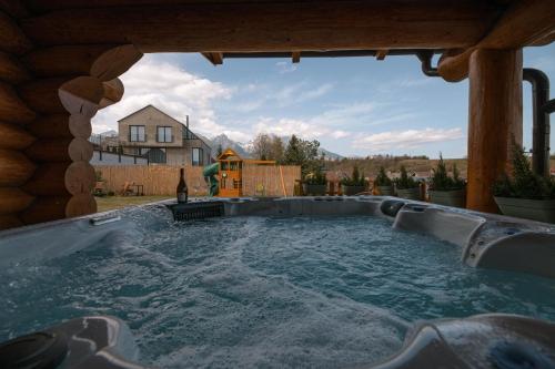 a hot tub in the backyard of a log cabin at Forest Chalet with Jacuzzi and sauna, 4 km from Starý Smokovec in Nová Lesná