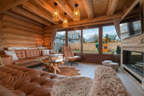 a living room with a couch and a fireplace at Forest Chalet with Jacuzzi and sauna, 4 km from Starý Smokovec in Nová Lesná