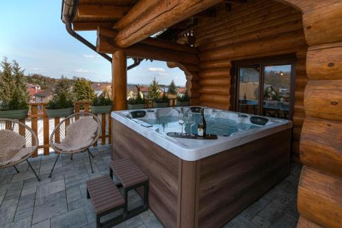 a hot tub on the deck of a log cabin at Forest Chalet with Jacuzzi and sauna, 4 km from Starý Smokovec in Nová Lesná