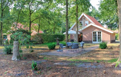 a brick house with a table and chairs in the yard at Three-Bedroom Holiday Home In Hoge Hexel in Hoge-Hexel