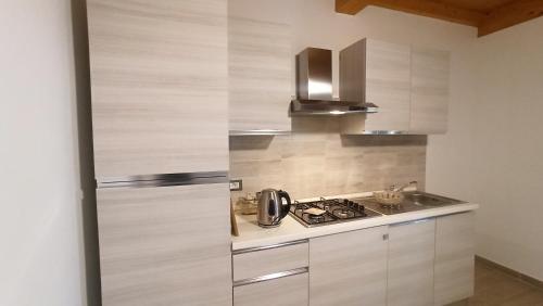 a kitchen with a refrigerator and a stove top oven at Agriturismo La tana della volpe in Alberese