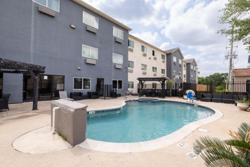 a swimming pool in front of a building at Wingate by Wyndham Humble/Houston Intercontinental Airport in Humble