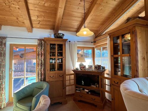 a living room with wooden ceilings and a room with a tv at Chalet Aurach in Aurach bei Kitzbuhel