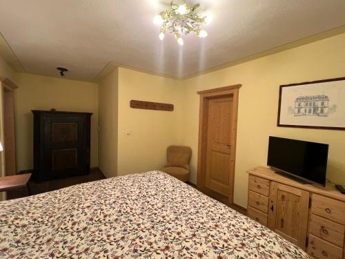 a bedroom with a bed and a flat screen tv at Chalet Aurach in Aurach bei Kitzbuhel