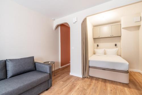 un salon avec un lit et un canapé dans l'établissement Studio Cozy Design - Batignolles, à Paris