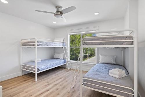 a room with two bunk beds and a window at Brand New LUX Townhome-Mins to Beaches, Game Room! in Hilton Head Island