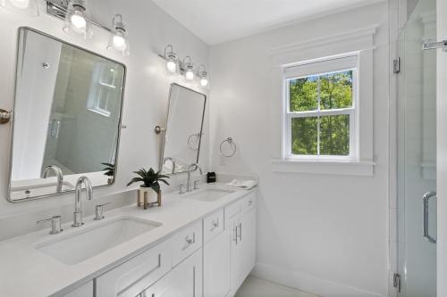 a white bathroom with two sinks and a shower at Brand New LUX Townhome-Mins to Beaches, Game Room! in Hilton Head Island