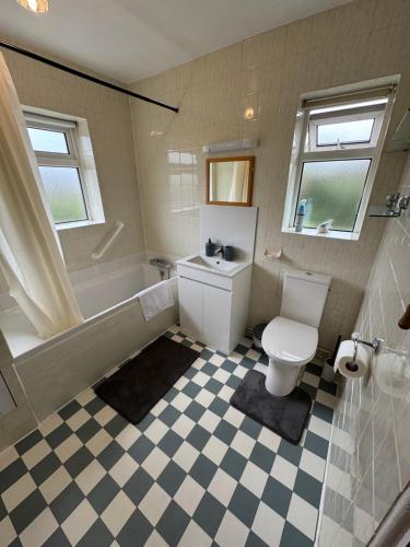 ein Badezimmer mit Toilette, Badewanne und Waschbecken in der Unterkunft Oxford 3 Bedroom Detached House, with Large Garden and Private Parking in Kidlington