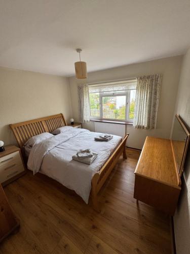 ein Schlafzimmer mit großem Bett und Fenster in der Unterkunft Oxford 3 Bedroom Detached House, with Large Garden and Private Parking in Kidlington