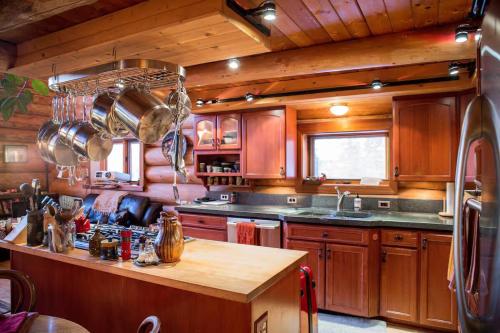 a kitchen with wooden cabinets and a large island at Moose Mountain Cabin- Cozy retreat with aurora views in Fairbanks