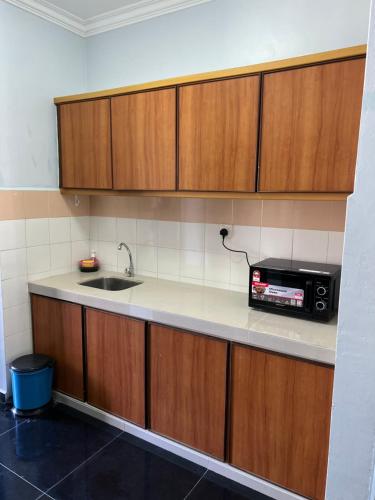 a kitchen with a sink and a microwave at Swiss Court Holiday Apartments in Lumut