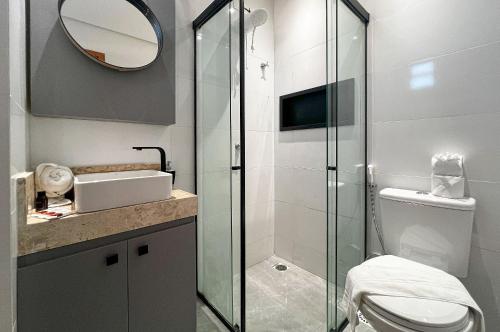 a bathroom with a toilet and a glass shower at Duplex Super Charmoso 200m Praia Bessa 3 Pessoas in Nossa Senhora do Livramento