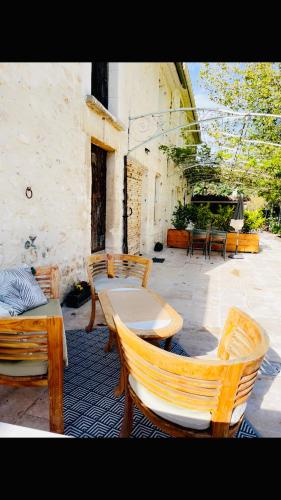 a patio with two chairs and a table and chairs at Le Mas d’Aloha in Plan-dʼOrgon