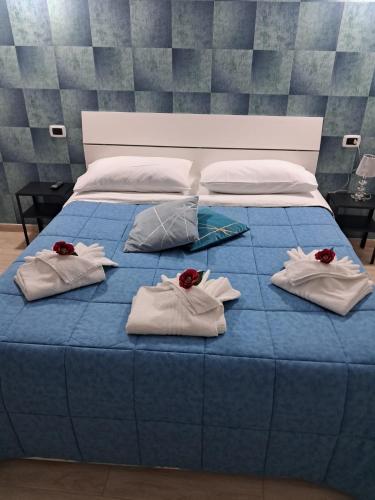 a blue bed with towels and red roses on it at La Petite Maison in Naples