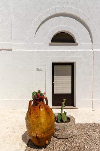 a large vase with flowers in front of a building at Luxery Resort Triglie in Crispiano