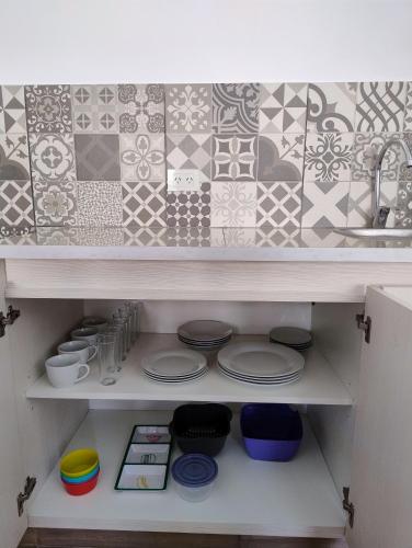 a kitchen shelf with plates and bowls and tiles at El Alfarero de Maimará - Cabaña Álamo in Maimará