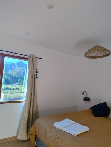 a bedroom with a bed and a window at El Alfarero de Maimará - Cabaña Álamo in Maimará