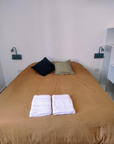 a bed with two towels sitting on top of it at El Alfarero de Maimará - Cabaña Álamo in Maimará