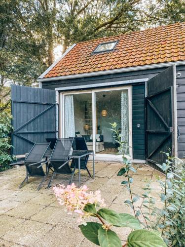 a house with a patio with chairs and a table at Vakantiehuis in de polder in Lewedorp