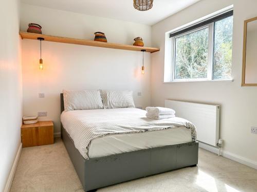 a bedroom with a bed with a shelf on the wall at Modern 3 Bed Home - Pets Welcome - FREE Parking in Canterbury