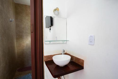 a bathroom with a sink and a tv on a wall at Departamento Novos Apart Catamarca Alquiler temporario in San Fernando del Valle de Catamarca