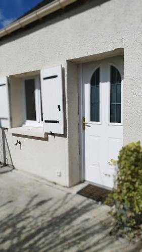 a white house with a door and windows at Maison Auguste - cosy - terrasse in Verberie