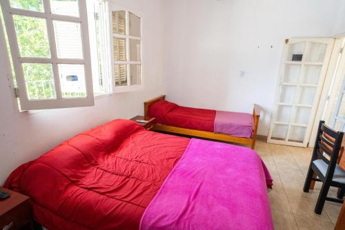 two beds in a room with pink sheets at Departamento Novos Apart Catamarca Alquiler temporario in San Fernando del Valle de Catamarca