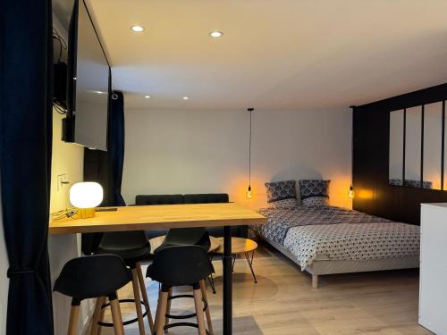 une chambre avec un lit, une table et des chaises dans l'établissement Grand Studio - Au Faubourg - Strasbourg Centre, à Strasbourg