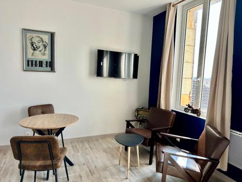 une pièce avec une table, des chaises et une fenêtre dans l'établissement Le studio Vintage du centre ville - Proche coeur historique, à Bergerac