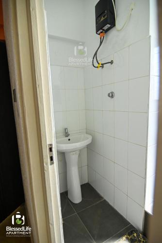 a bathroom with a white toilet and a sink at Frimpong Home - Blessed life Apartment in Kumasi