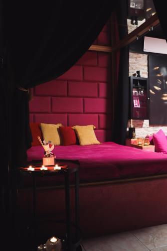 a bedroom with a purple bed and a table at WELLNESS privátní - Brno in Lískovec