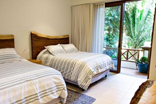 Higuera BlancaにあるDepartamento en Litibu Punta Mitaのベッドが2つと大きな窓がある寝室