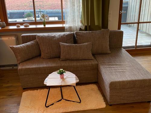 a brown couch with a table in a living room at Heimelig im Allgäu in Scheidegg