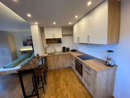 a kitchen with white cabinets and a wooden counter top at Heimelig im Allgäu in Scheidegg