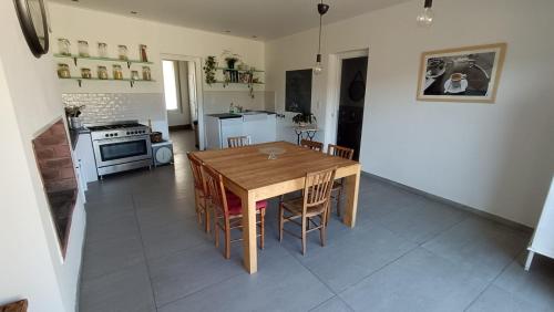 une cuisine et une salle à manger avec une table et des chaises en bois dans l'établissement Le Clos des Mimosas, à Béziers