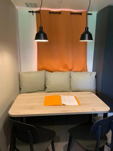 a table with two chairs and a couch with two lights at Camping La Saline d'Arc et Senans in Arc-et-Senans