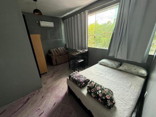 a bedroom with a bed with pillows and a window at Hotel e Restaurante Casa Paraense Original, px ao aeroporto in Manaus