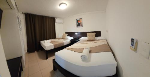 a room with two beds in a hotel room at Book & Sleep Cancun in Cancún