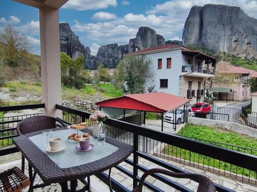 una mesa en un balcón con vistas a las montañas en Heliopetra, en Kalambaka